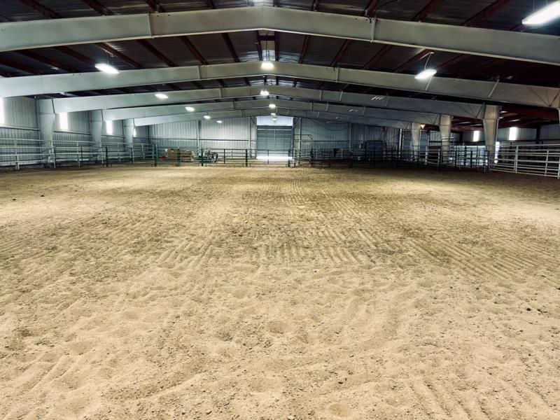 A large indoor arena with a lot of sand on the floor