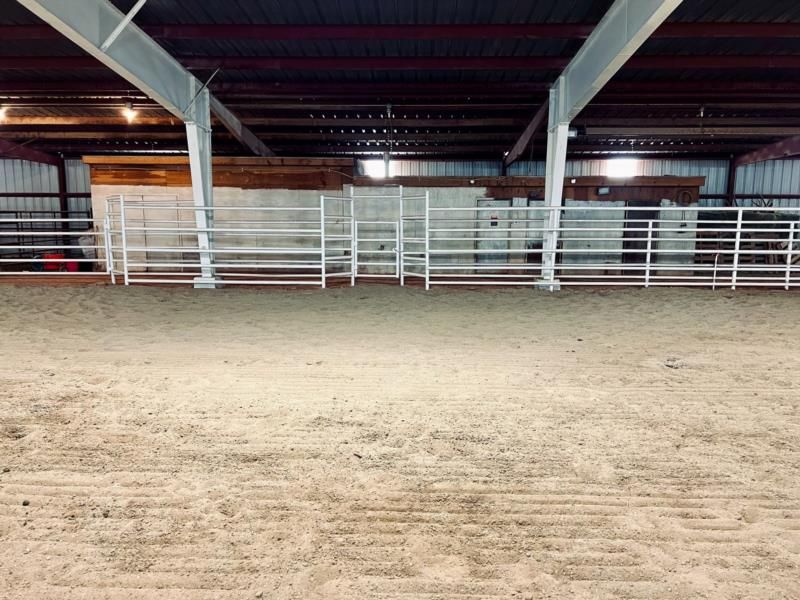 A large empty arena with a fence in the background