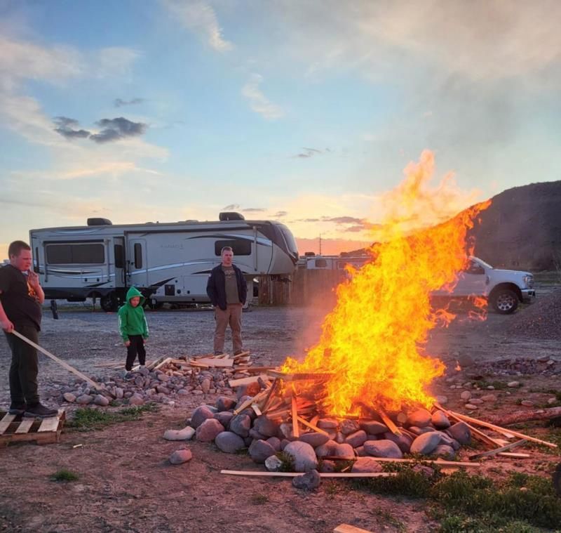 A group of people are standing around a fire in a parking lot.