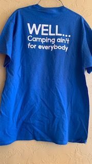 A bright blue t-shirt hanging on a wall with the white text,