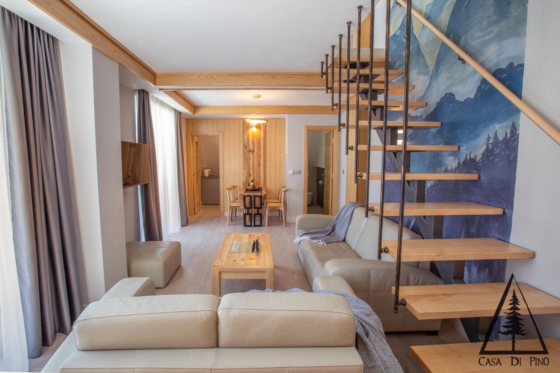 A living room with a staircase leading up to the second floor