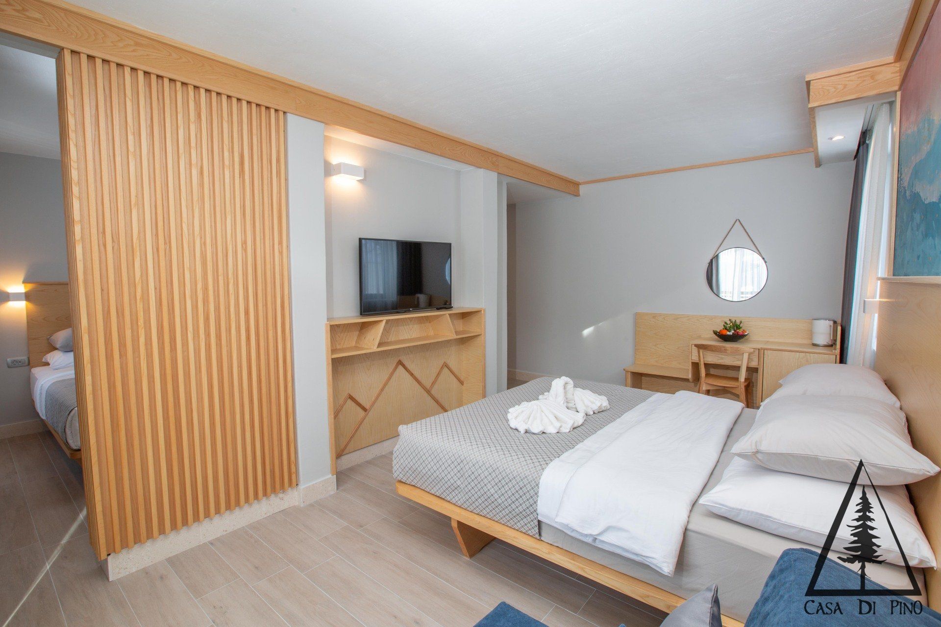 A hotel room with a king size bed and a flat screen tv.