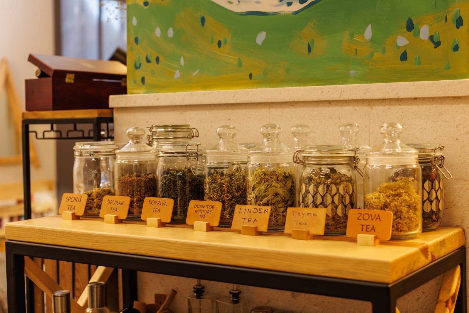 A wooden table topped with jars filled with different types of tea.