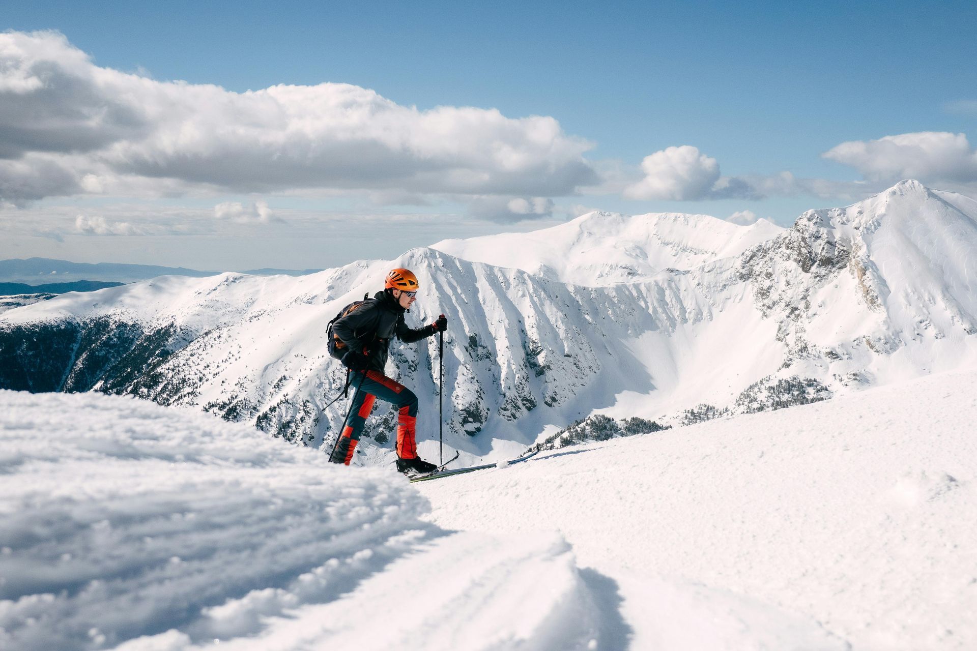 A person is skiing down a snow covered mountain.