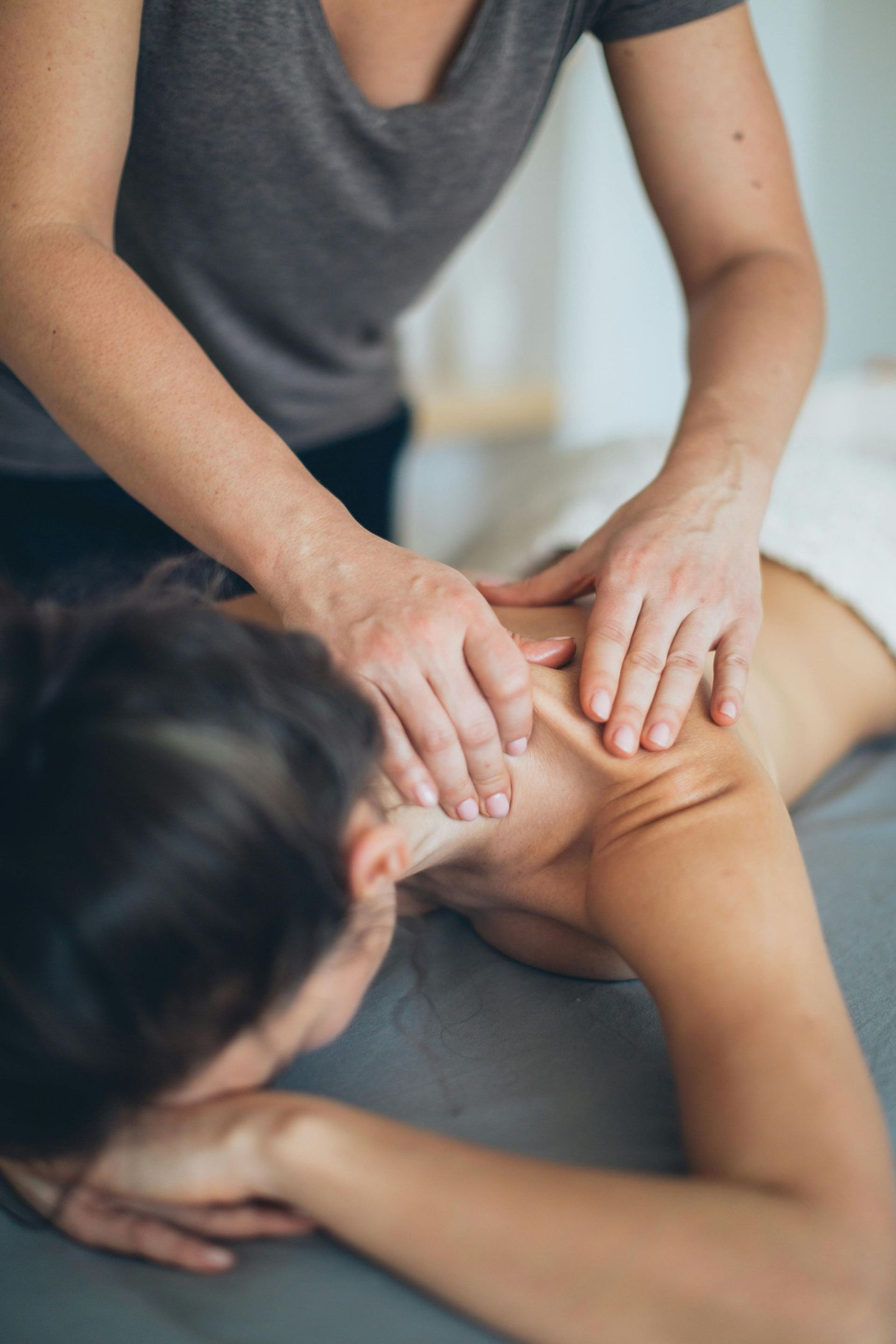 A person massaging shoulders of another person.