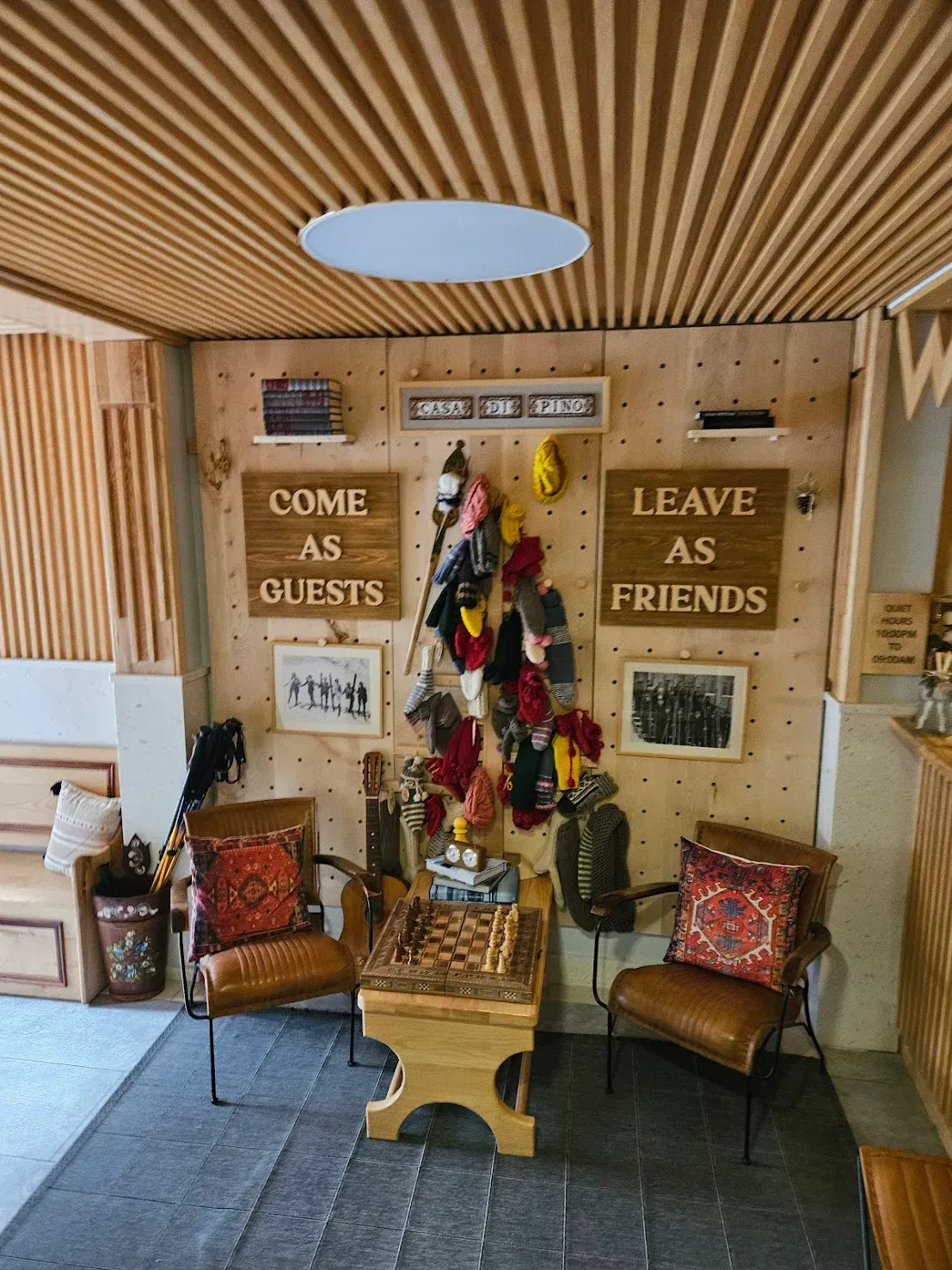 Cozy interior with wood paneling, leather chairs, chess table, wall decor, and the quote 