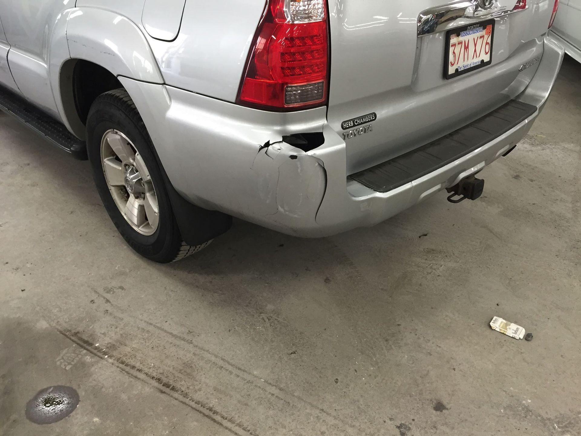 Silver SUV with rear bumper damage.
