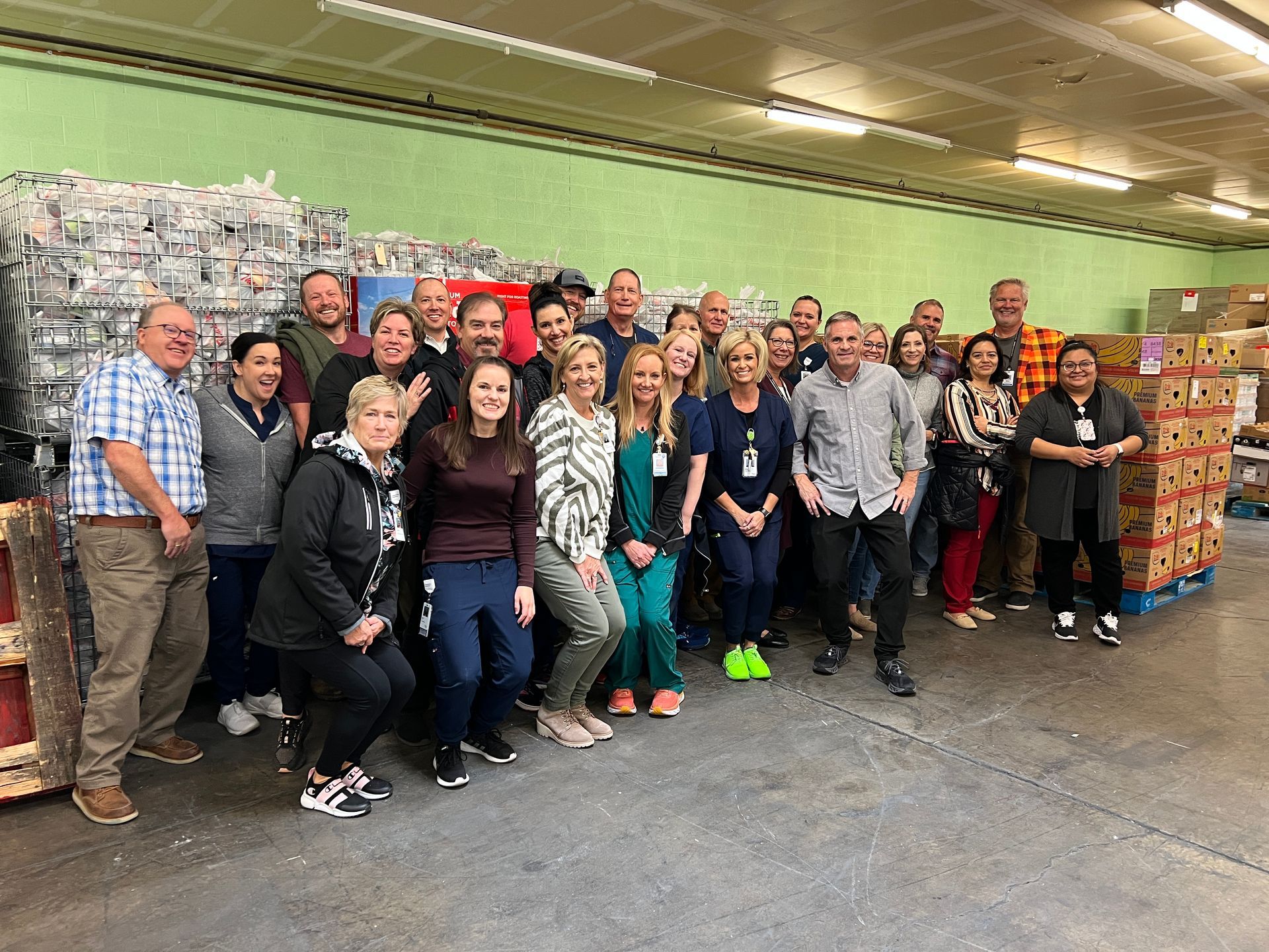 A group of people are posing for a picture in a warehouse.