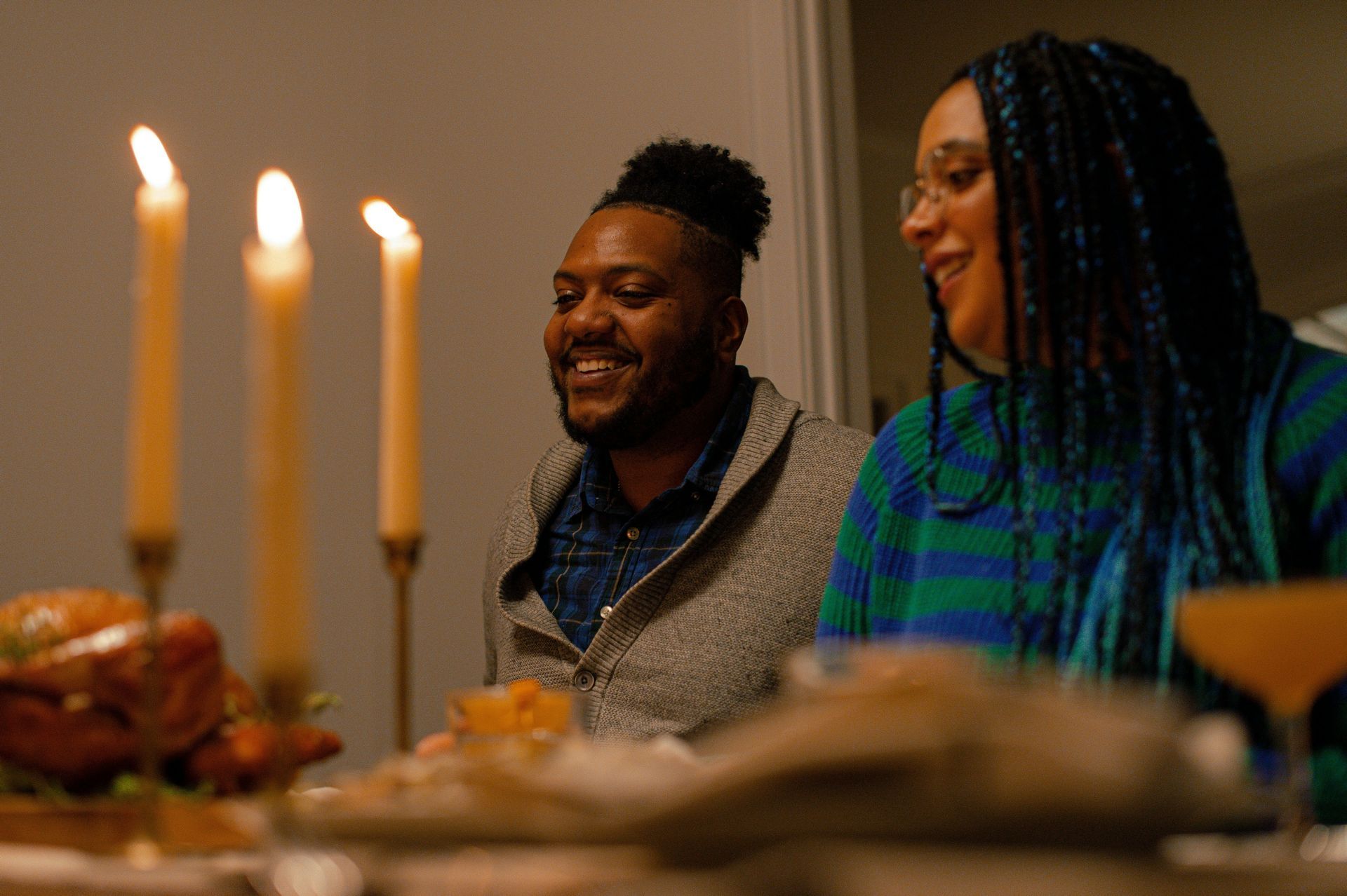 A man and a woman are sitting at a table with candles.