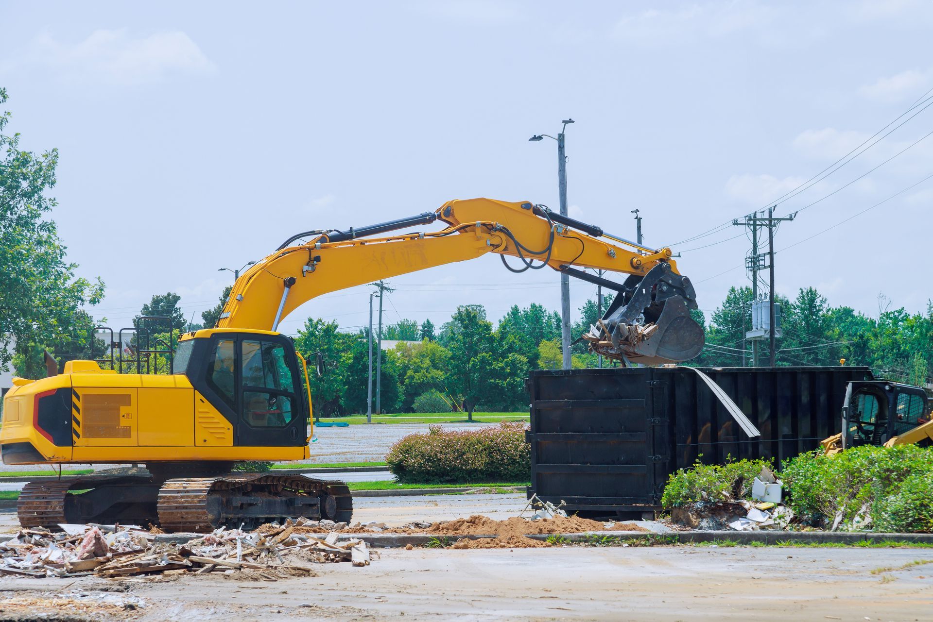 Excavator loading dumpster of Paradise Junk Removal