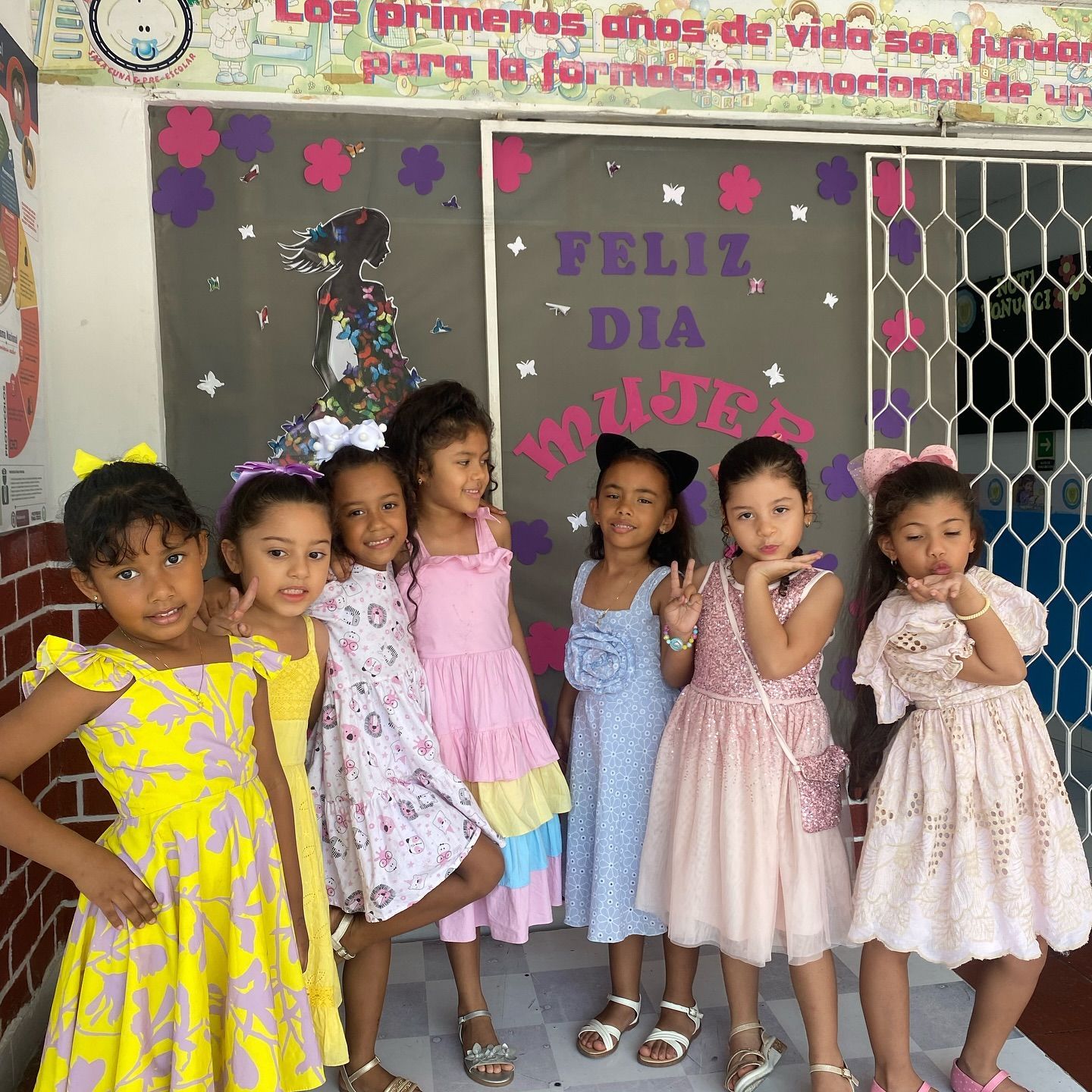 Niños sentados a una mesa, jugando a un juego de apilar aros de madera de colores.
