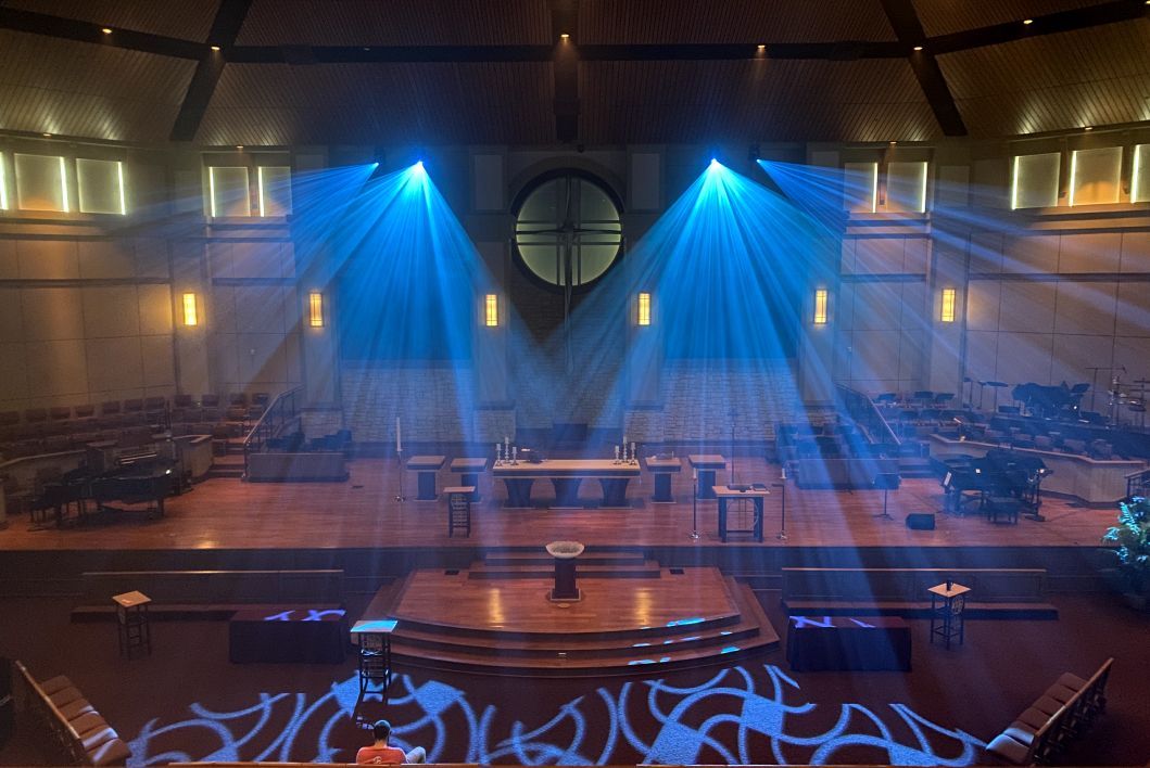 An empty church with blue lights on the stage