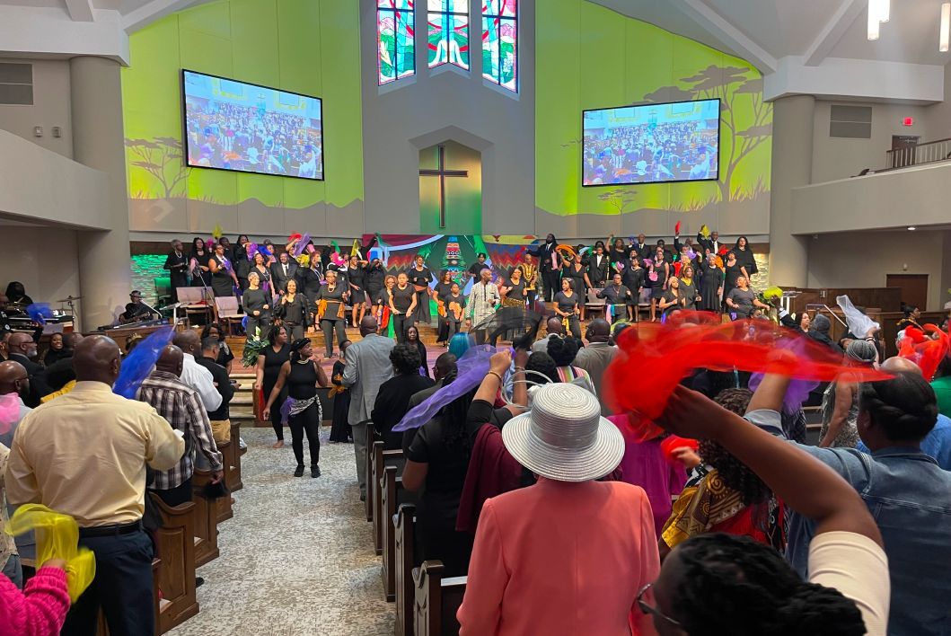 A large group of people are standing in a church.