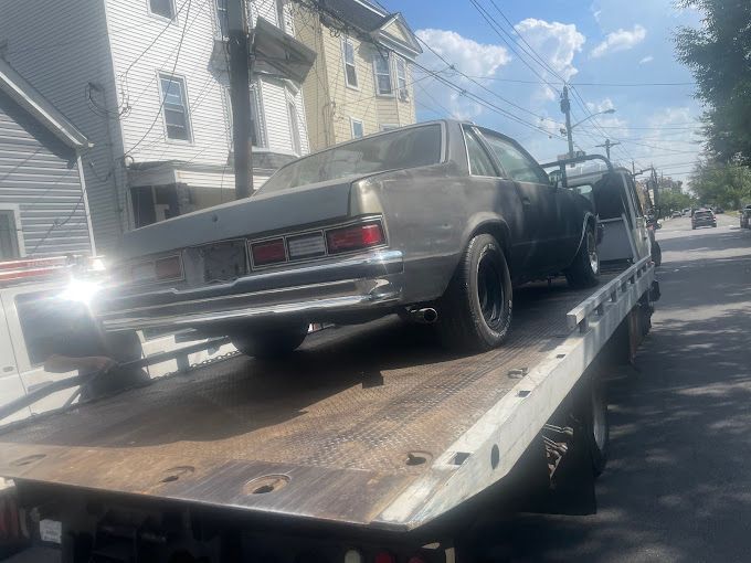 A car is sitting on top of a tow truck.