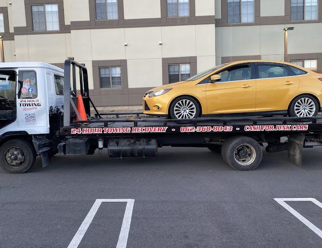 A yellow car is sitting on top of a tow truck.