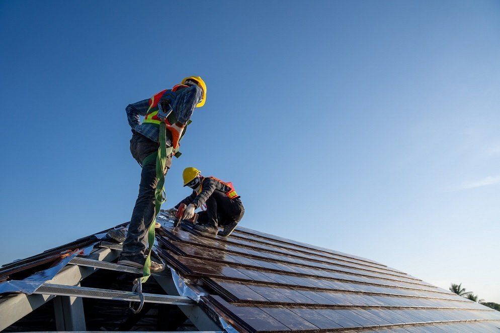 Two roofing contractors replacing the tiles of a damaged roof in Hobart, TAS