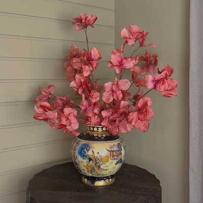 Vintage keramieken vaas met handgeschilderde details, gevuld met roze zijden bloesemtakken