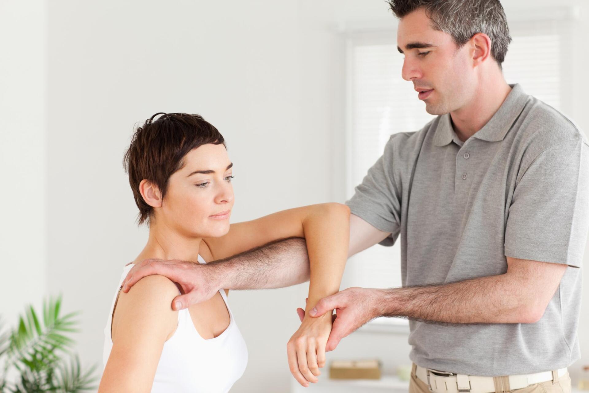therapist holding the womans hand and shoulders