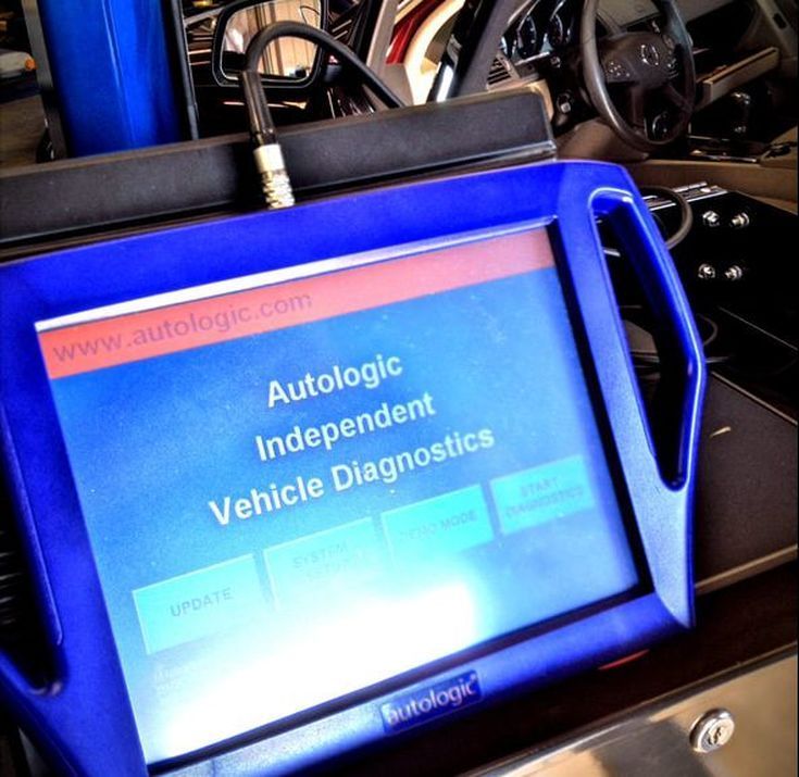 Blue Autologic  diagnostics tablet mounted inside a car interior, showing a menu screen