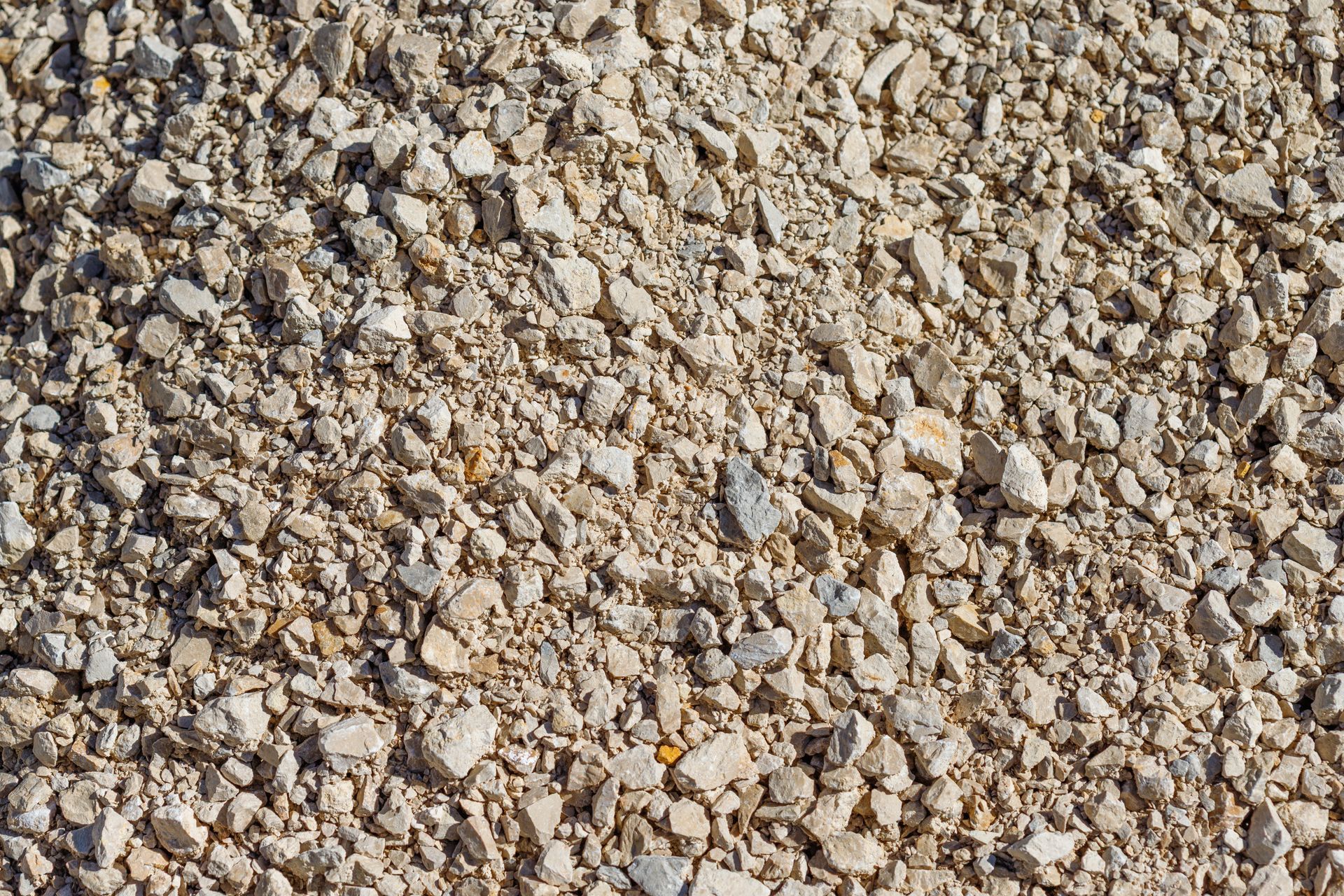 Close-up of a pile of light-colored, irregularly shaped gravel stones.