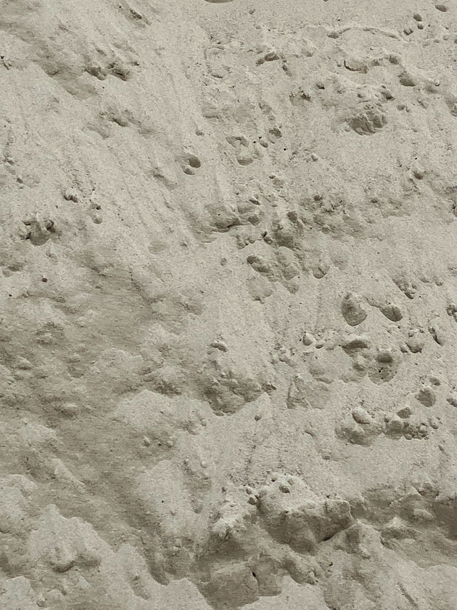 Bucket of sand with trowel, resting on a gray tiled patio.