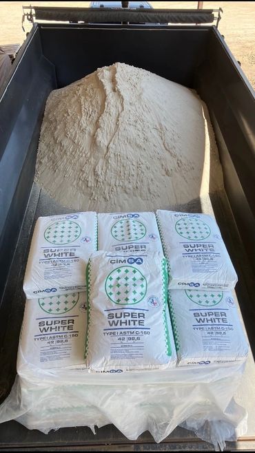 Truck bed filled with white powder and six bags labeled