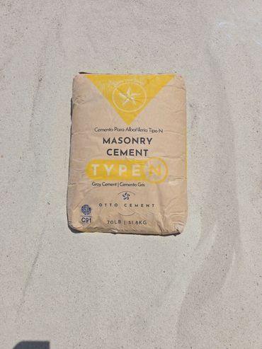 Masonry cement bag, Type N, on a light gray surface, with yellow and cream-colored packaging.