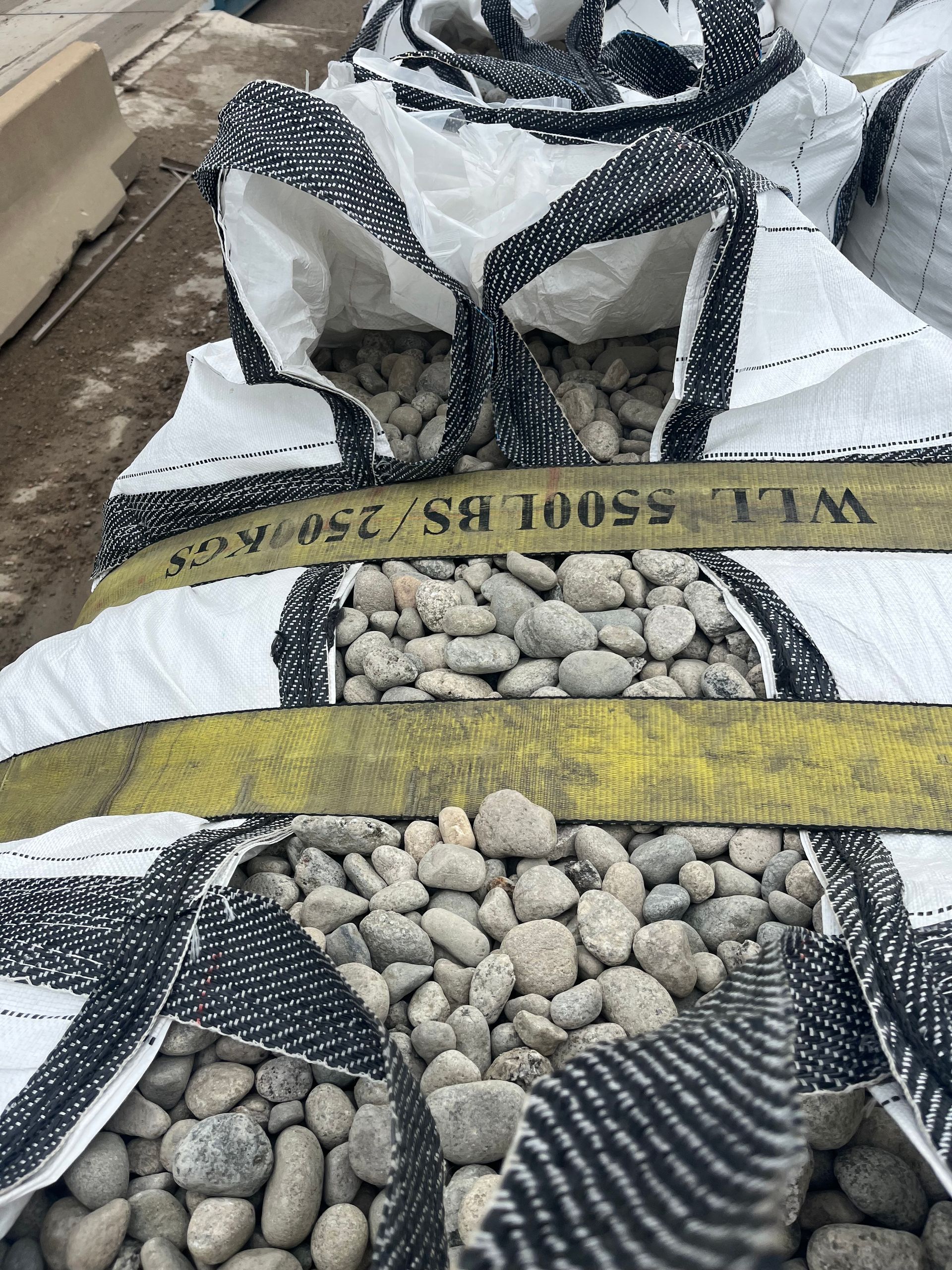 A person is standing in front of a pile of rocks.