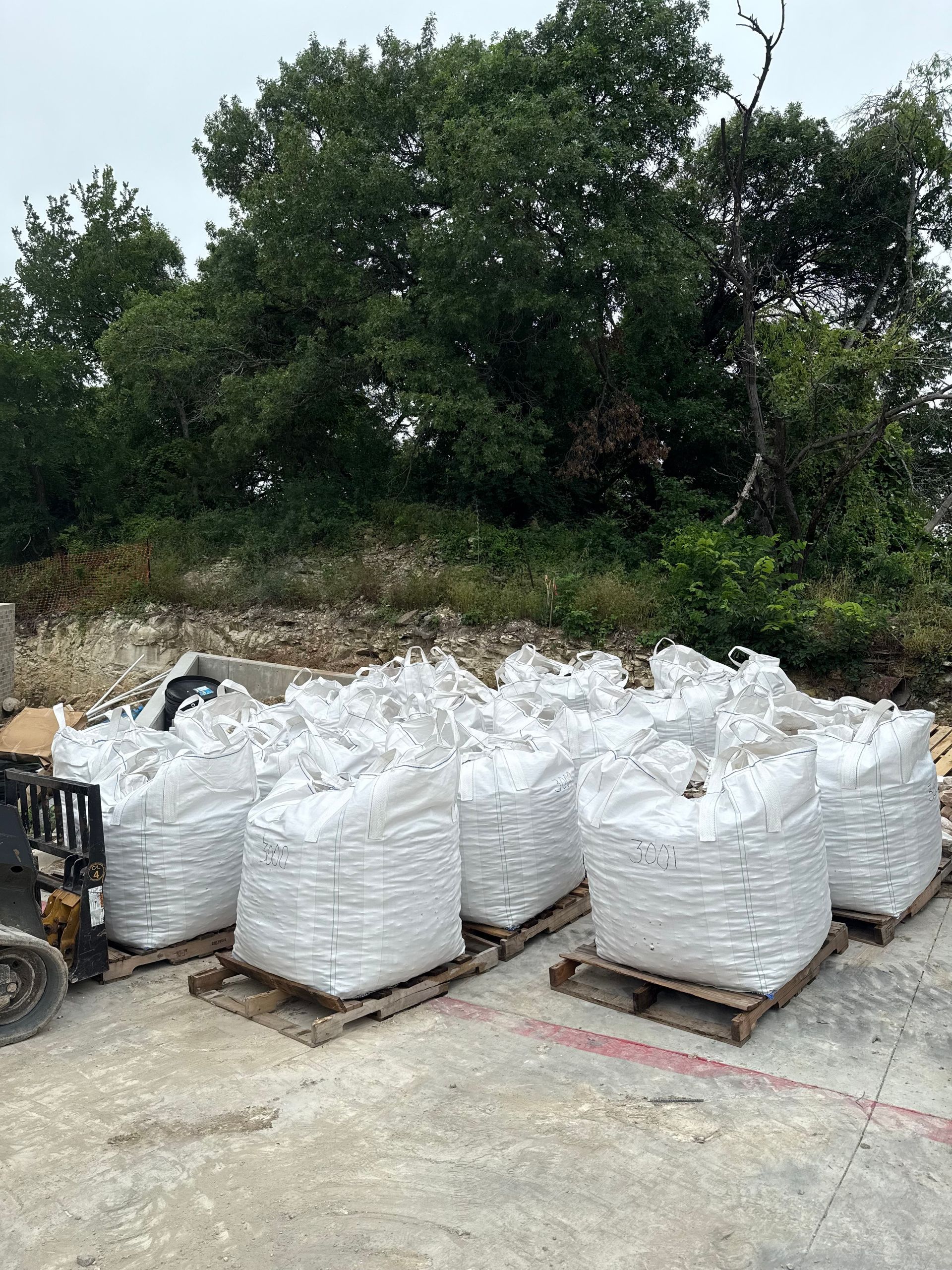 A person is standing in front of a pile of rocks.