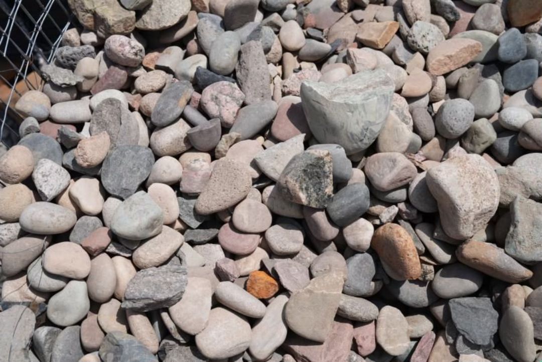 A pile of rocks is sitting on top of a fence.