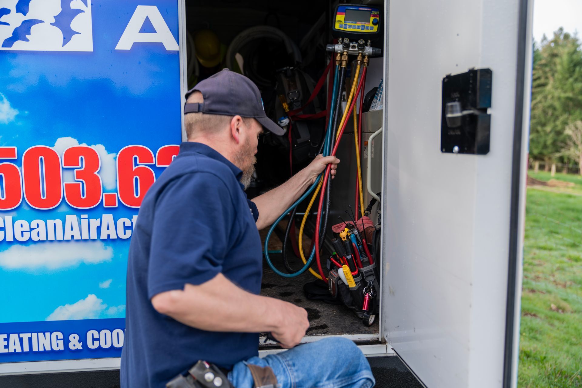 The Clean Air Act Technician is working on an air conditioner in a trailer.