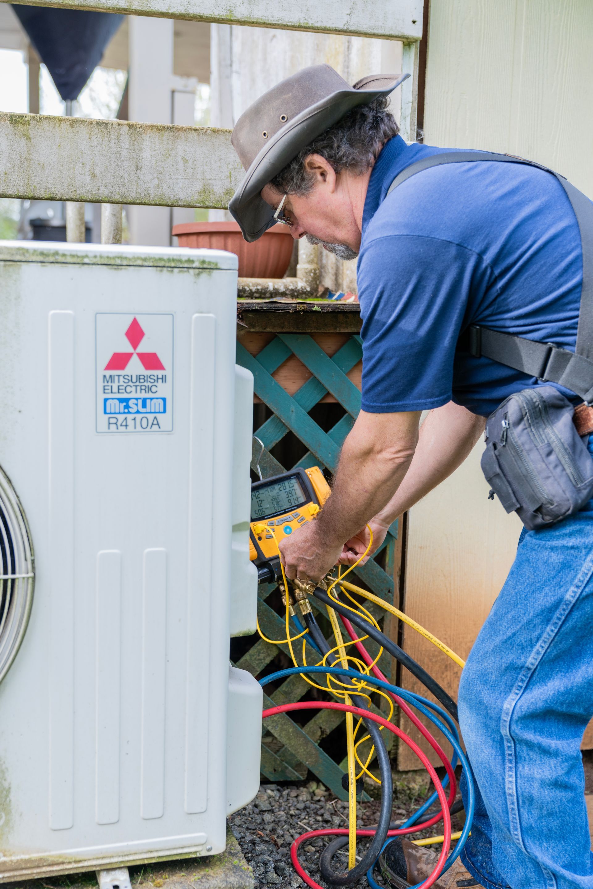 The Clean Air Act Technician is working on a mitsubishi air conditioner.