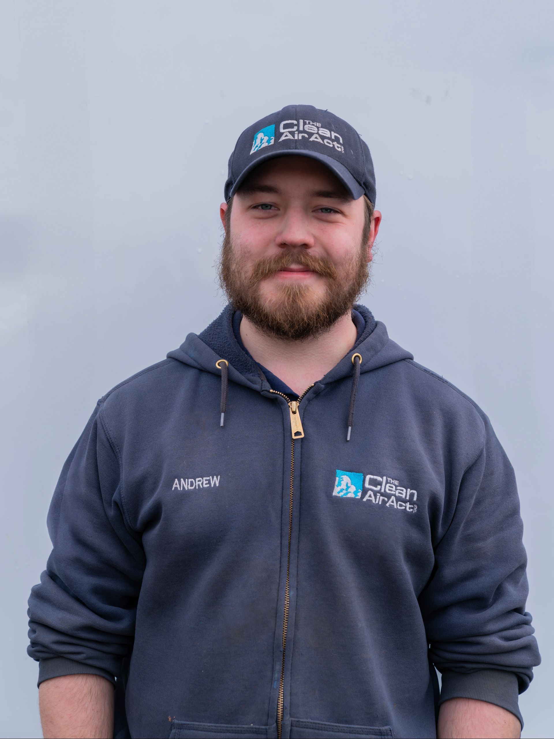 A man with a beard is wearing a hat and a hoodie.