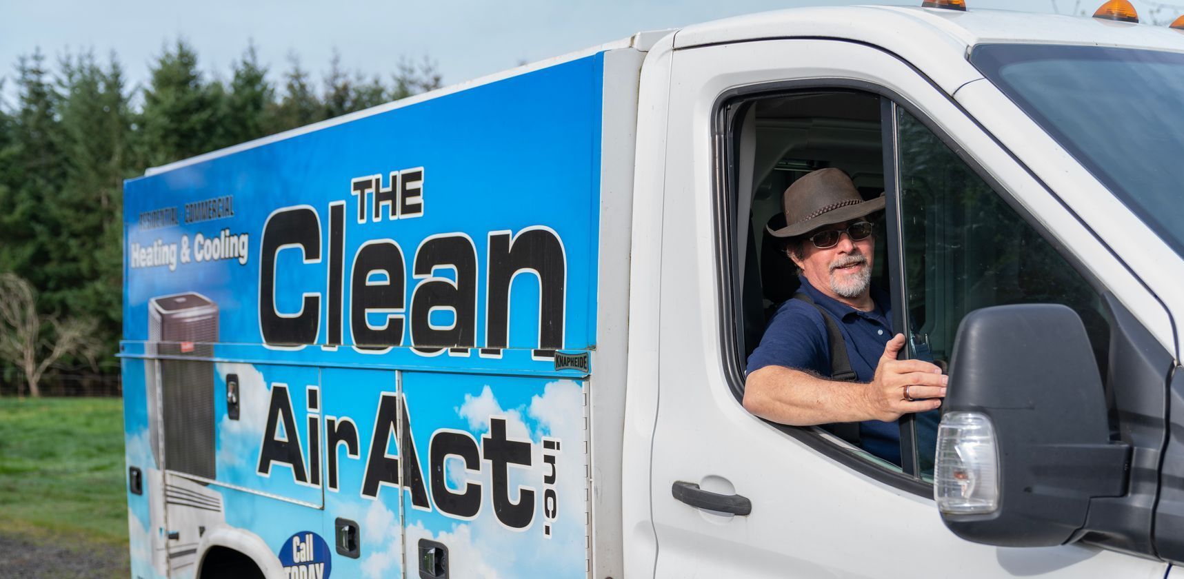 The Clean Air Act Technician is sitting in the driver 's seat of a clean air act truck.