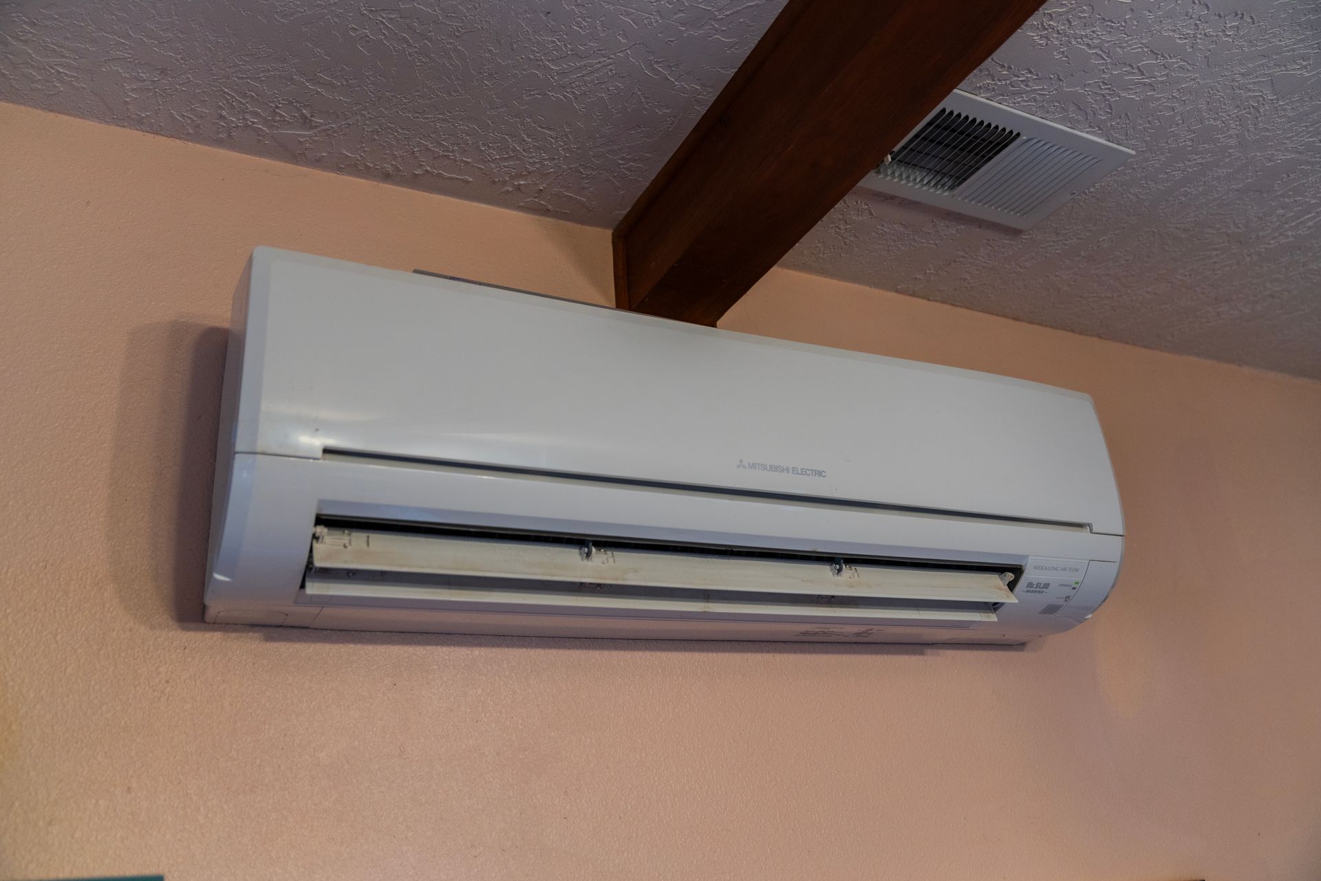 A white air conditioner is hanging on a wall.