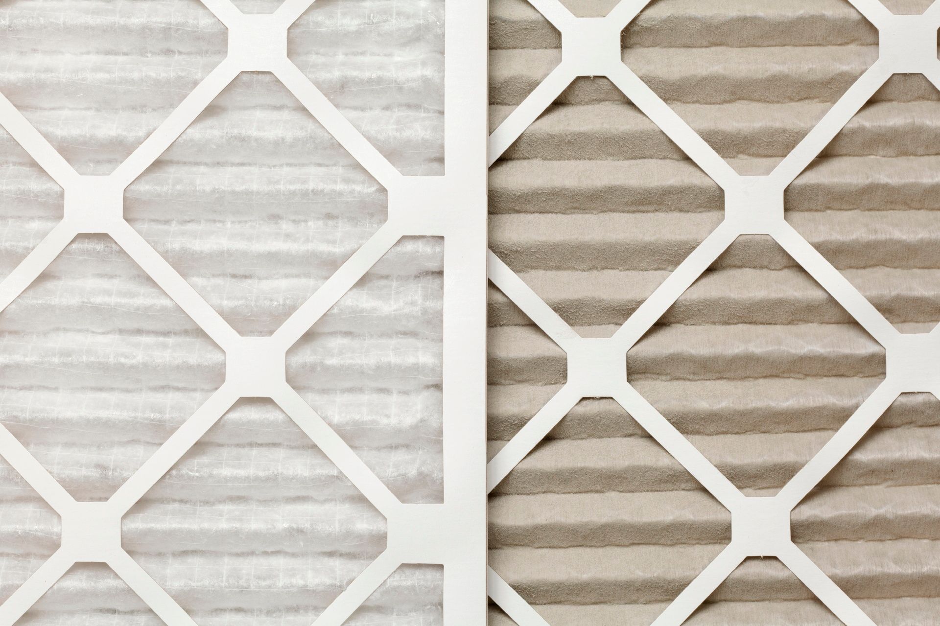 A close up of two air filters , one clean and one dirty.