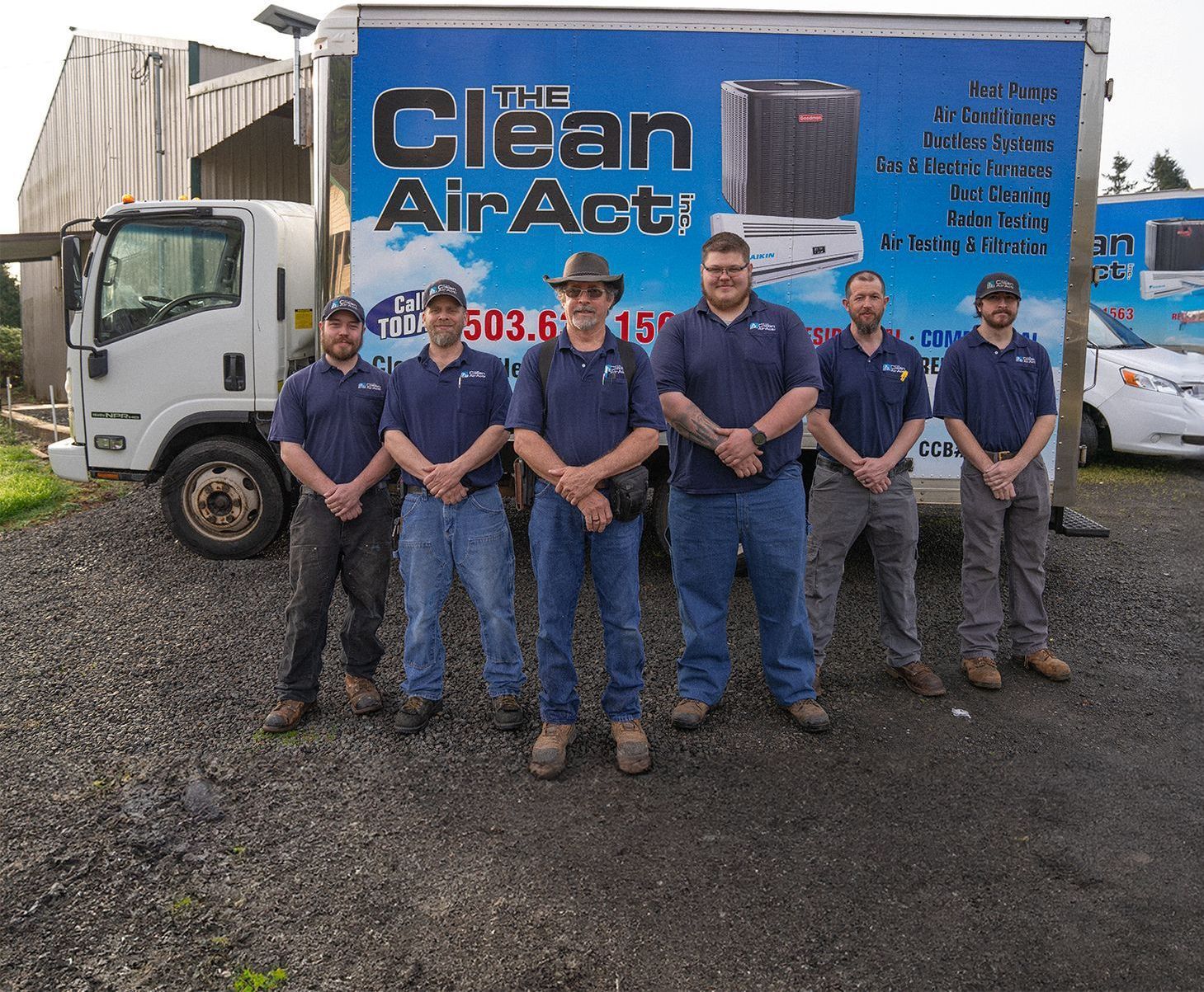 The Clean Air Act Technicians standing in front of a truck that says clean air acti