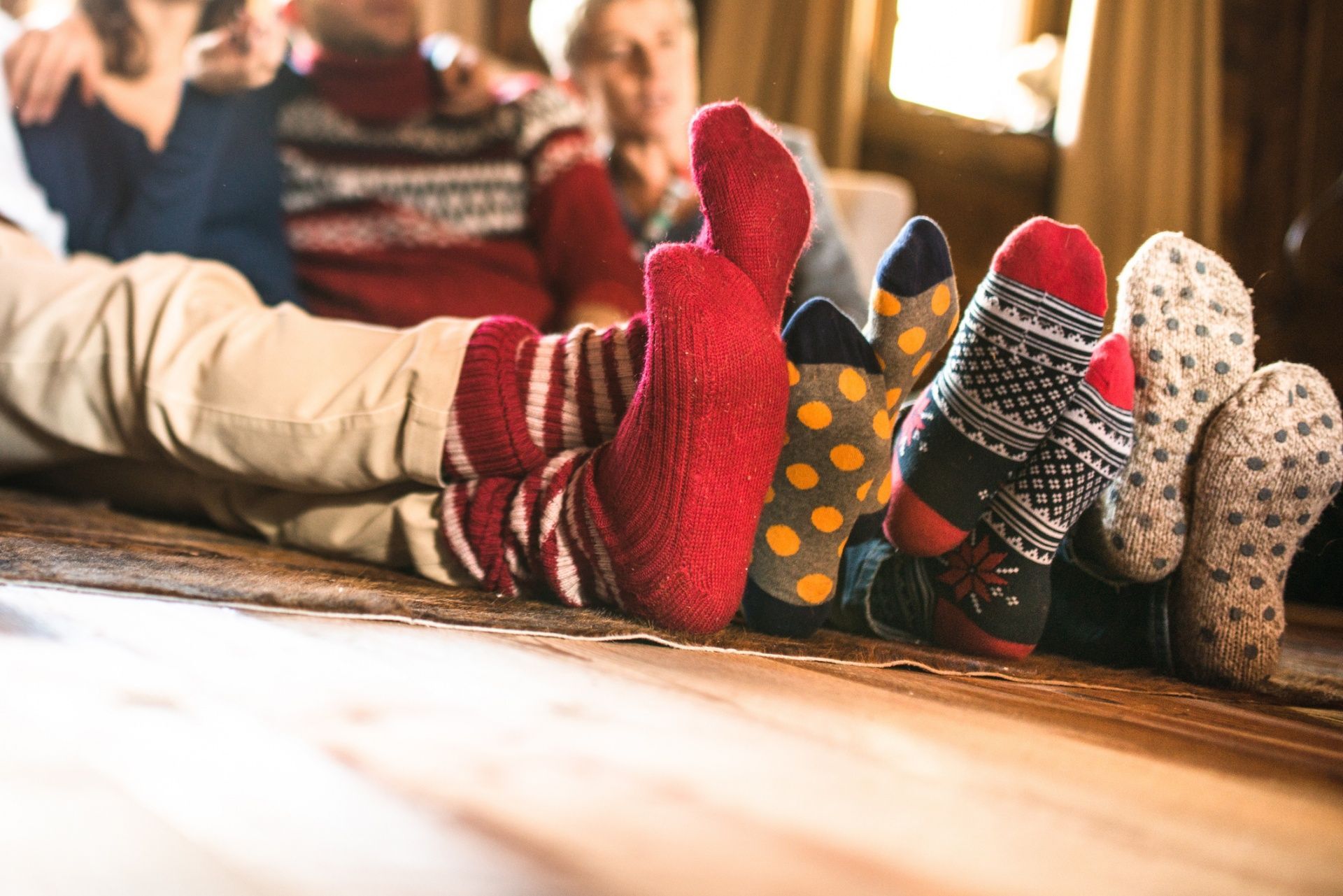 A group of people are laying on the floor wearing socks.