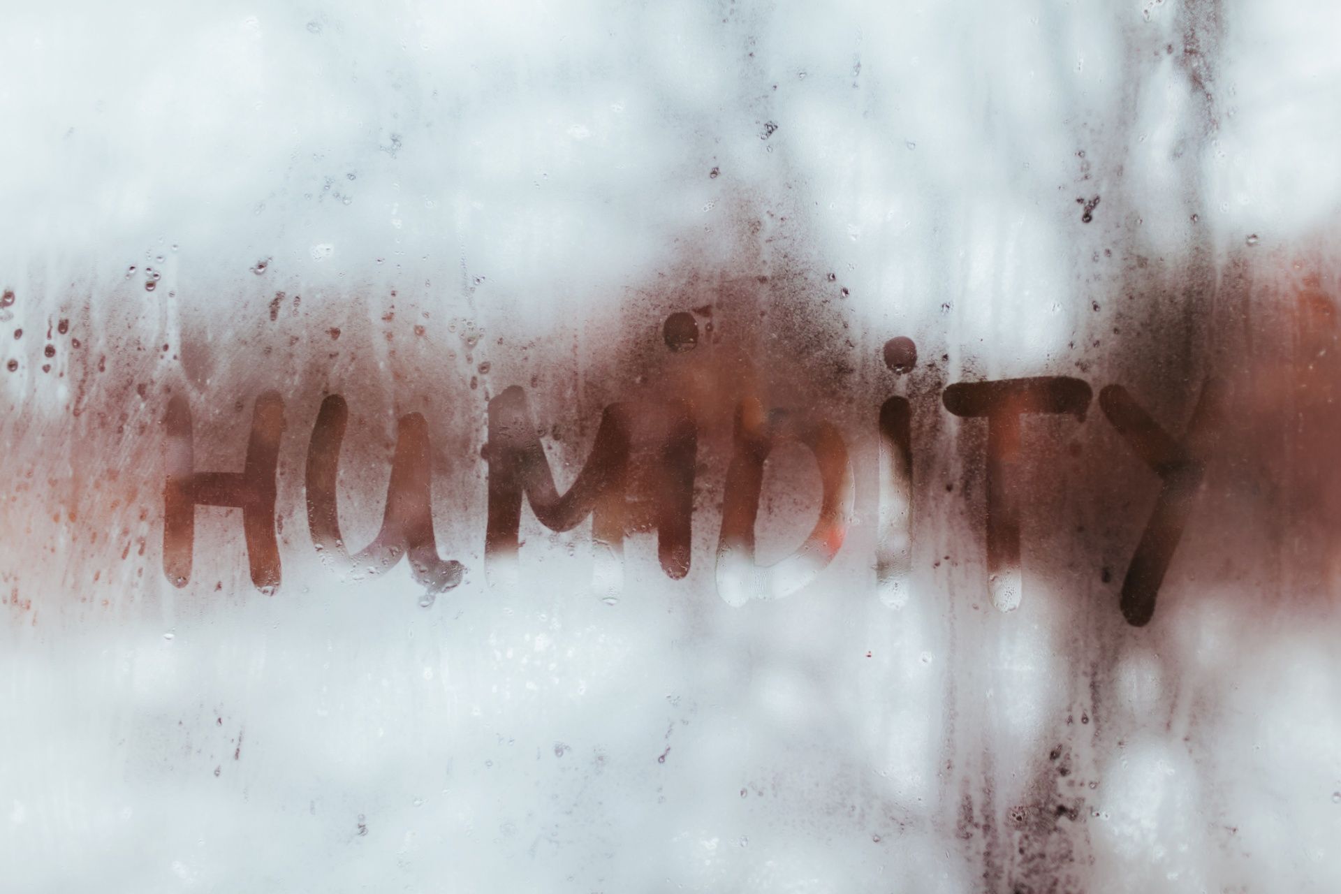 The word humidity is written on a foggy window.