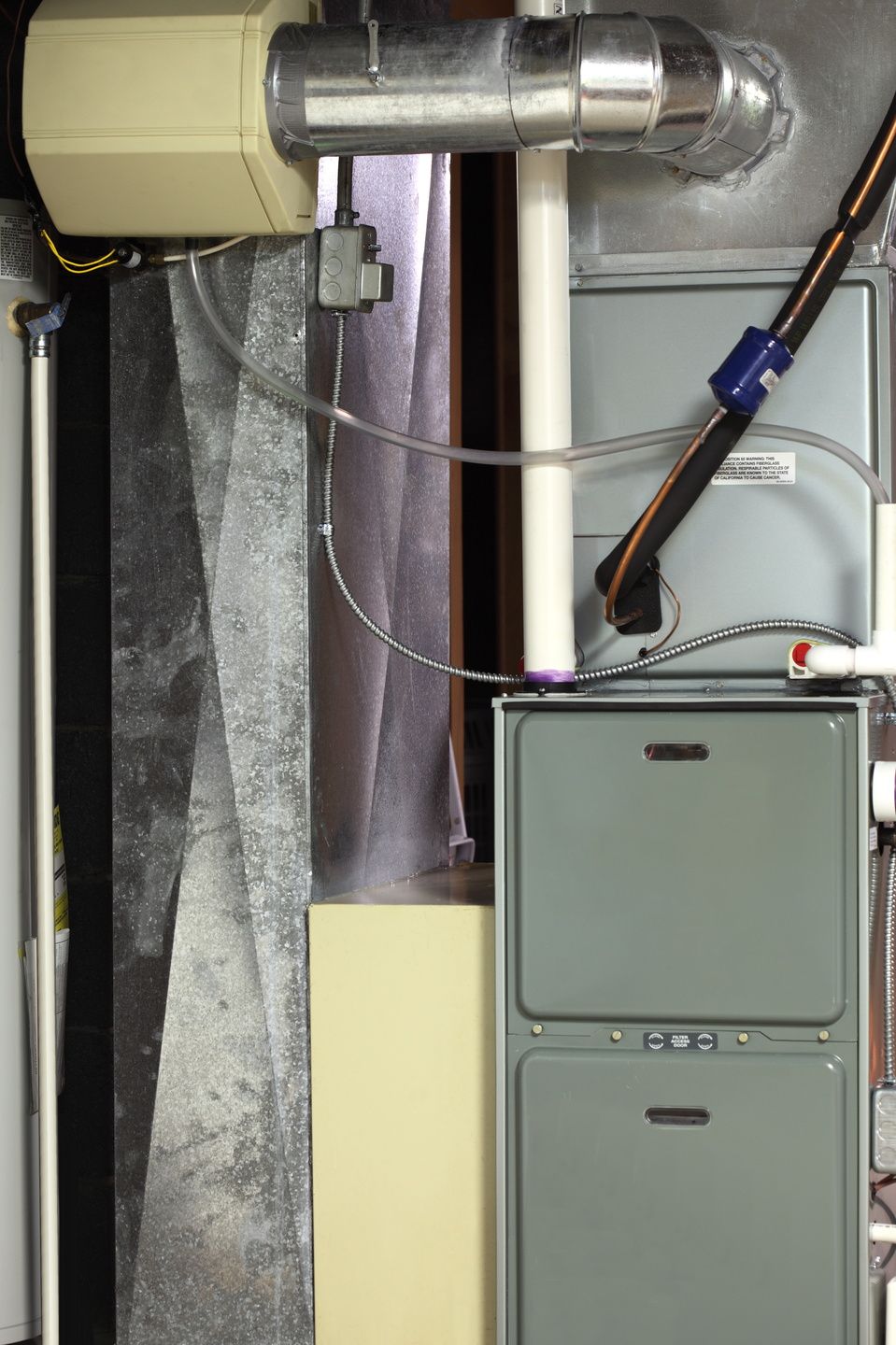 An air conditioner is sitting in a room next to a window.