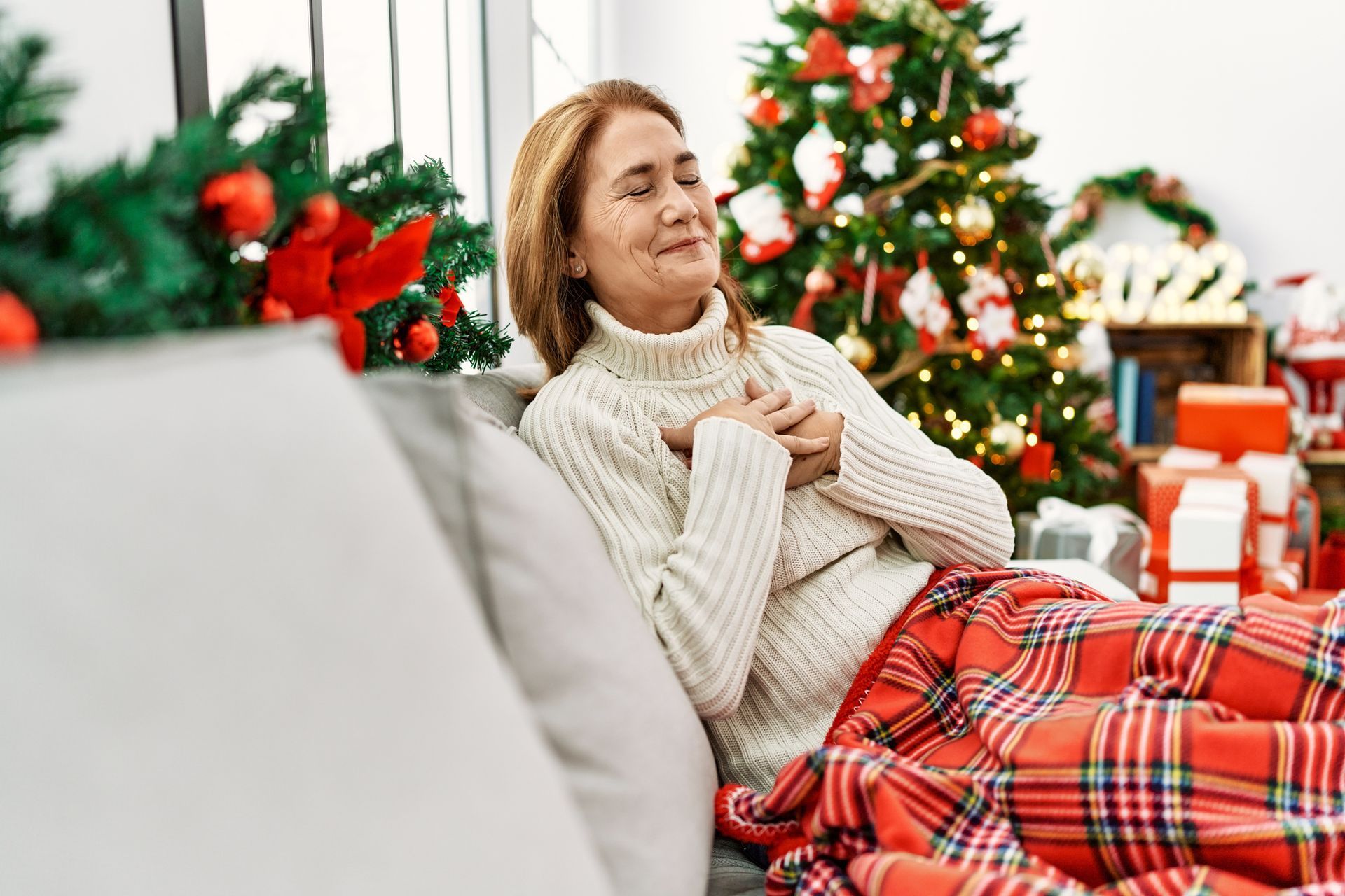 A woman relaxing indoors during the holidays in a Portland home with clean, healthy indoor air.
