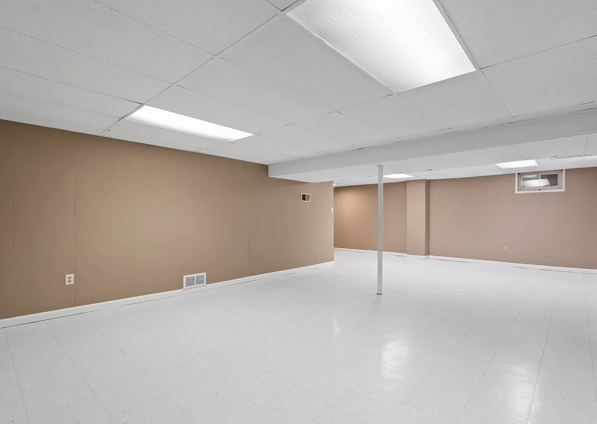 Fully finished basement with a lounge area, built-in lighting, and durable flooring for extra living space.