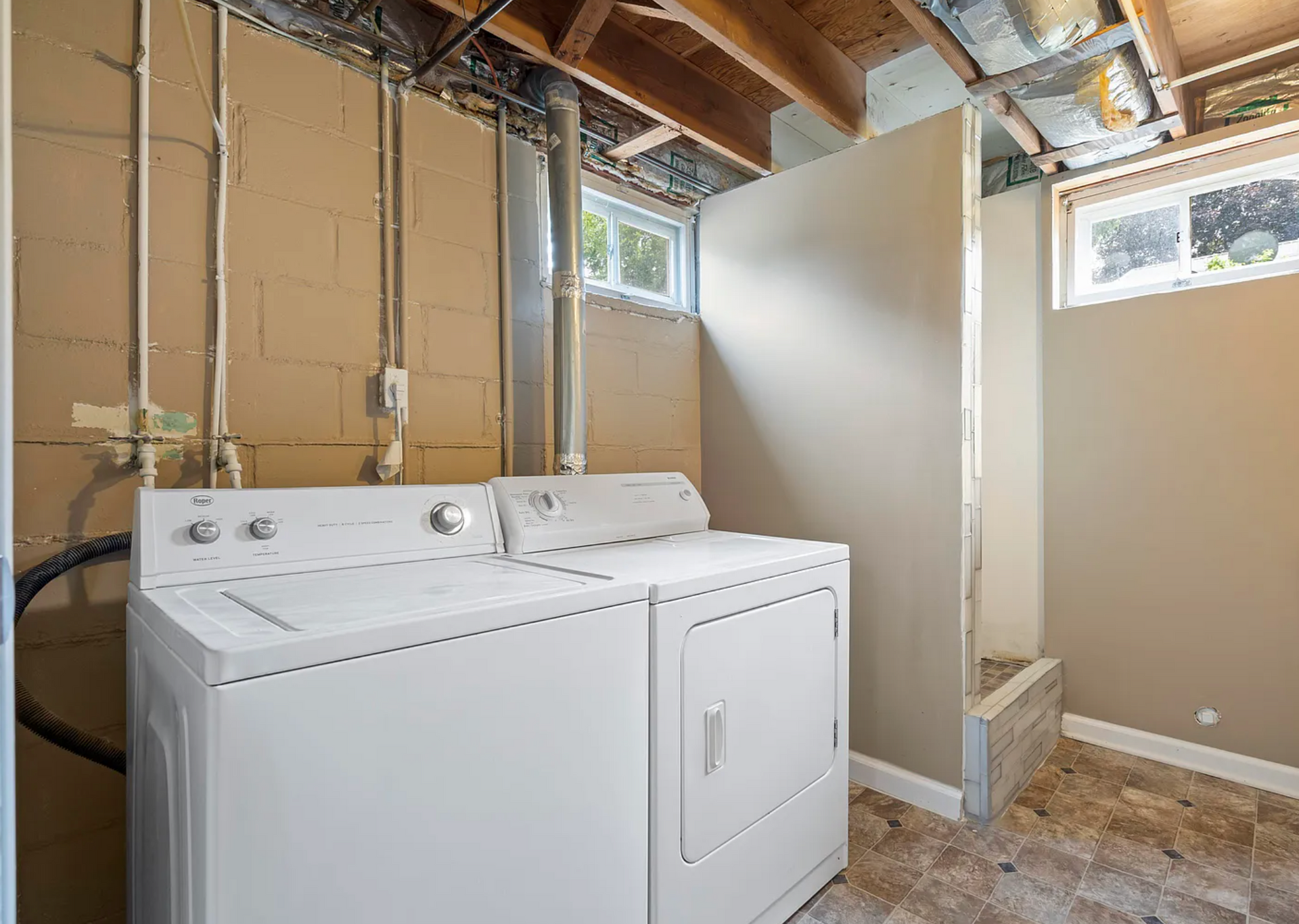 Upgraded laundry room with sleek cabinets, a modern washer and dryer, and efficient storage solutions.