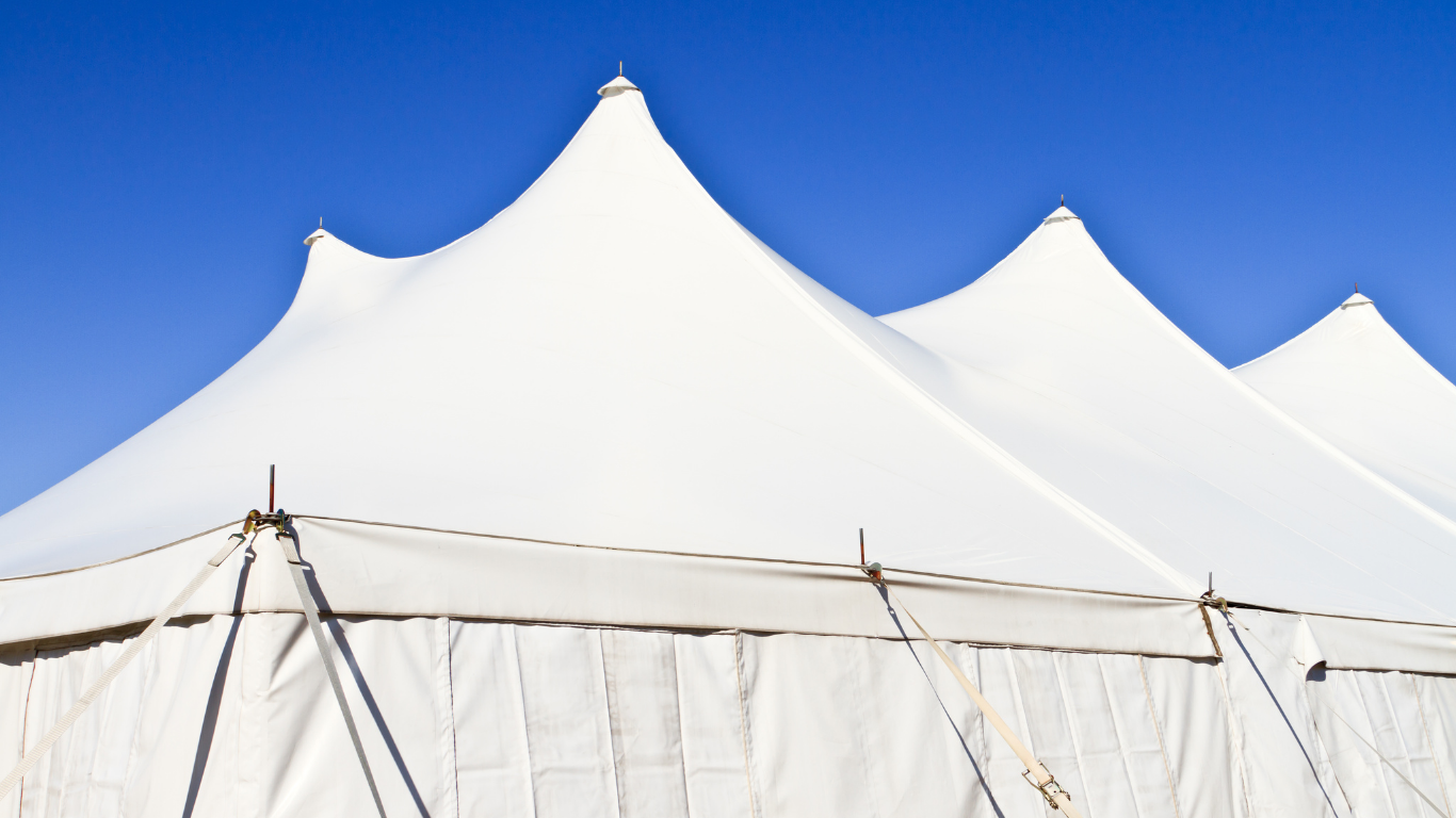 White tent tops against a vibrant blue sky.