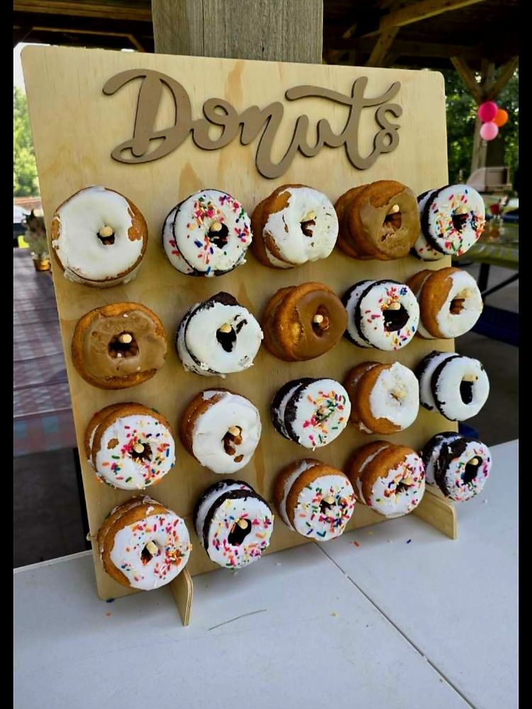 Donut display with assorted frosted donuts on a wooden board. 