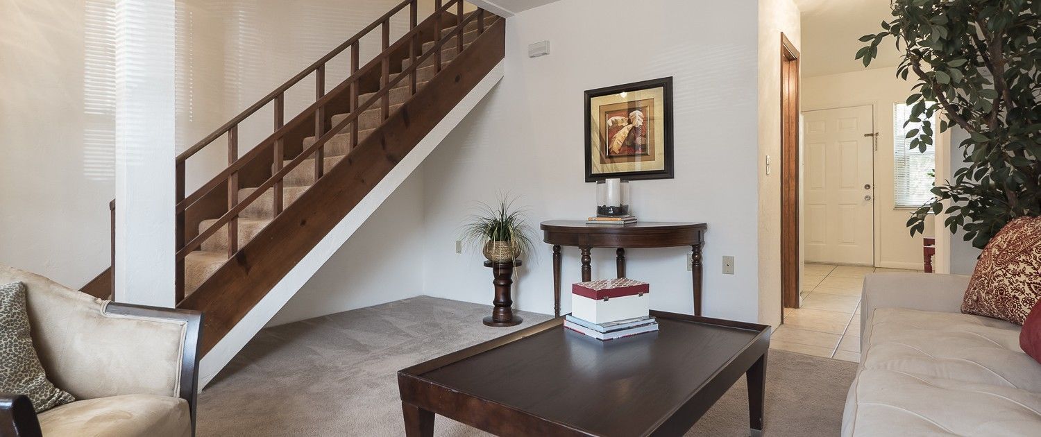 Photo of a living room with a staircase in the background