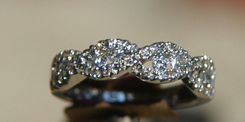 A close up of a diamond ring on a table.