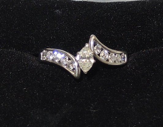 A close up of a diamond ring on a black surface