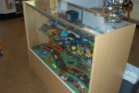A display case filled with lots of toy cars in a store.
