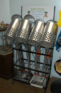 A bunch of surf scoops are sitting on a rack in a room.